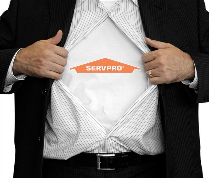 Man opening his T-shirt, inside he has another T-shirt that says SERVPRO